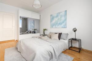 Un dormitorio blanco con una cama y un espejo. en North Estate Vestregata - Central - Fantastic view, en Tromsø