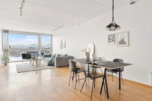 Una sala de estar blanca con una mesa y sillas. en North Estate Vestregata - Central - Fantastic view, en Tromsø