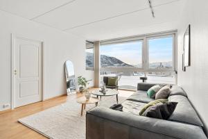 Una sala de estar con un sofá y una ventana grande. en North Estate Vestregata - Central - Fantastic view, en Tromsø