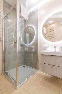 a shower with a glass door in a bathroom at Aqua Park Residence VIPAPARTAMENTY in Zakopane
