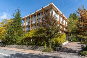 a large building with trees in front of it at Aqua Park Residence VIPAPARTAMENTY in Zakopane