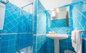 a blue tiled bathroom with a sink and a shower at Le Residenze del Maria Rosaria - Vico Friuli 1 in Orosei