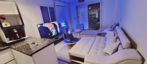 ein Wohnzimmer mit einem weißen Sofa und einem Fernseher in der Unterkunft cozy apartment , La Sirena Palm Beach ,Ain Sokhna in Ain Suchna