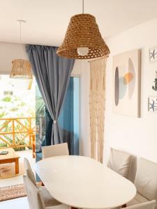 ルイース・コヘイアにあるCondomínio Vila do Mar - Apartamento 3 quartosの白いテーブルと椅子のある白いダイニングルーム