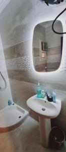 ein weißes Badezimmer mit Waschbecken und Spiegel in der Unterkunft cozy apartment , La Sirena Palm Beach ,Ain Sokhna in Ain Suchna