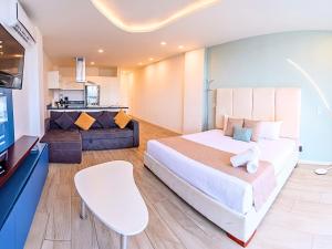 Un dormitorio con una cama y una sala de estar. en Mare Condo Vacacional Playa del Carmen, en Playa del Carmen 83 fotos más