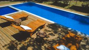 an overhead view of a wooden deck next to a swimming pool at Villa Cacau - Floresta in Trancoso