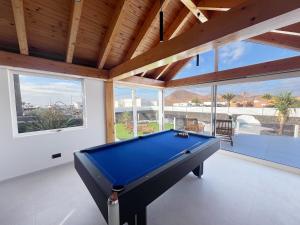 una mesa de billar en una habitación con ventanas en Chalet Cueva del Sol, en Tahiche