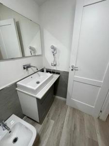 une salle de bain blanche avec un lavabo et un miroir dans l'établissement Lake Resort & SPA Experience, à Castel Volturno