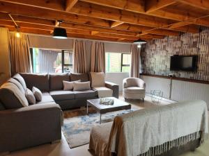 a living room with a couch and a tv at Goodnight Guest Lodge in Johannesburg