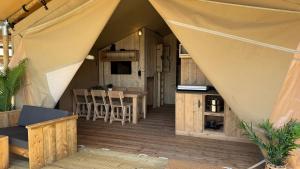 a tent with a kitchen and a dining room at Safari Lodge B in Petten