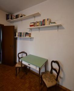 a room with a table and two chairs and books at Ca di Nà in Entracque