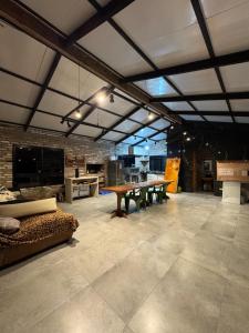 ein Wohnzimmer mit Tisch und Couch in der Unterkunft Pico da neblina in Farroupilha