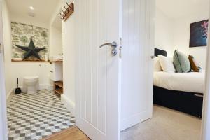 a bedroom with a bed and a room with a bathroom at Little Gem in the Forest of Dean! Hot tub, Private garden, Dog Friendly, Smart TVs and Beautiful Historic Village Location! in Saint Briavels +40 photos