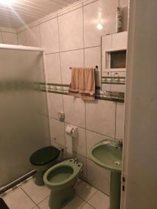a bathroom with a green toilet and a sink at Casa Familia Sítio Alto interior in São Joaquim