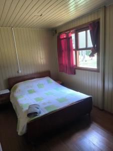 a bedroom with a bed in a room with a window at Casa Familia Sítio Alto interior in São Joaquim