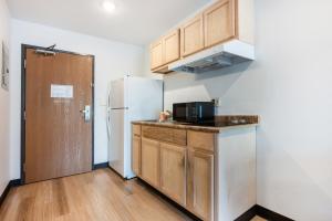 a kitchen with a refrigerator and a counter top at Suburban Studios Huntsville University Area in Huntsville
