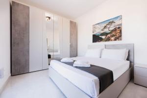 Un dormitorio blanco con una gran cama blanca. en PH Jacuzzi & Stunning Terrace Near Tarxien Temples, en Tarxien