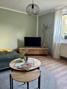 a living room with a coffee table and a television at Ferienwohnung Dorfliebe 