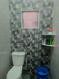 a bathroom with a white toilet and a mirror at Aahana Homestay in Merlimau +15 photos