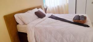 a bed with pillows and a basket on it at The Oval House in Otse