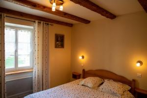 a bedroom with a bed and a window at La Ferme du Franz in Diefmatten