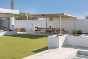 an outdoor patio with a picnic table and grass at Villa Rocio in Chiclana de la Frontera