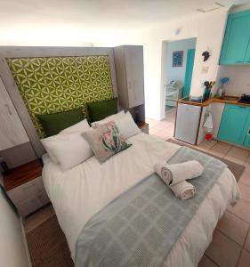 a bedroom with a large white bed with towels on it at Seaside haven in Simonʼs Town