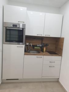 une cuisine blanche avec un évier et un micro-ondes dans l'établissement private parking,old town,52m2,terrace,no stairs, newly renovated,, à Ingolstadt 4 autres photos