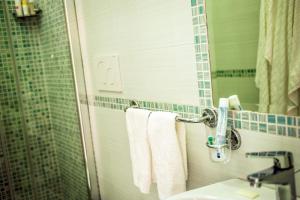 a bathroom with a sink and a mirror and towels at Hotel Regina del Mare in Ischia