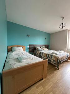 Sainte-Marie-CappelにあるGîte à la fermeの青い壁の部屋にベッドが2つある