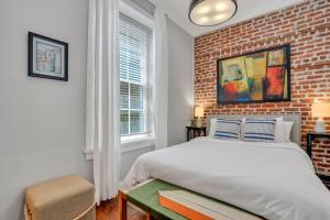 a bedroom with a brick wall and a bed at Home at 1014 in Savannah +57 photos