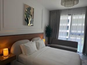 une chambre avec un lit, un canapé et une fenêtre dans l'établissement Maison Sahab - Stylish Studio in Tiraz Building, à Charjah
