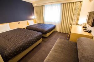 ein Hotelzimmer mit zwei Betten und einem Fenster in der Unterkunft Hotel Asia Center of Japan in Tokio