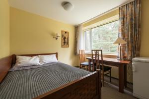 a bedroom with a bed and a desk and a window at ORO Dubingiai in Giraičiai  +38 photos