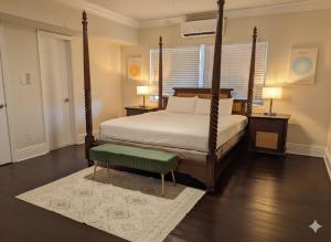 Un dormitorio con una cama con dosel y un banco verde. en La Casa Hotel, en Fort Lauderdale 20 fotos más