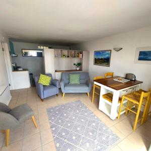 a living room with a table and a couch and chairs at Seaside haven in Simonʼs Town