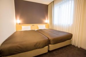 ein Schlafzimmer mit einem großen Bett und einem Fenster in der Unterkunft Hotel Asia Center of Japan in Tokio