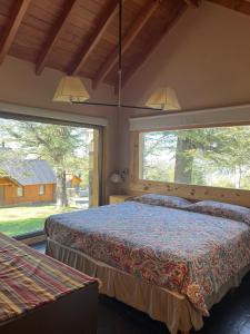 Un dormitorio con dos camas y una gran ventana. en Huella Blanca, en San Martín de los Andes