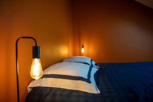 Un dormitorio con una cama con dos almohadas y una lámpara. en Le Loft - Place Flore - Besançon, en Besançon