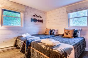 2 Betten in einem Zimmer mit Holzwänden und Fenstern in der Unterkunft Hike, Ski and Relax Renovated Retreat in Wilmington in Wilmington + 37 Fotos
