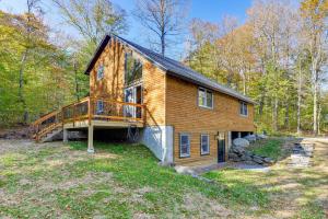 ein großes Holzhaus mit einer Terrasse im Wald in der Unterkunft Hike, Ski and Relax Renovated Retreat in Wilmington in Wilmington