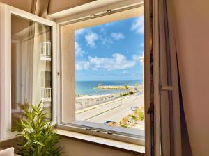 カステル・ヴォルトゥルノにあるDemetra Seafront Apartment - Parking & Poolのビーチを望む窓