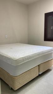 a mattress sitting on a bed frame in a room at Casa 70mt2 Mobiliada Centro Gaivota 400mt do Mar Wifi TV Smart in Balneário Gaivotas