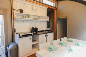 una cucina e una sala da pranzo con tavolo e sedie di Paarden lodge a Hoogersmilde Altre 5 foto