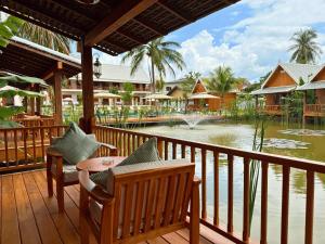 a balcony with chairs and a table and a pond at The Jam Boutique Hotel in Luang Prabang