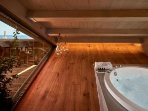 a bathroom with a tub on a wooden floor at Domus Renier Boutique Hotel - Historic Hotels Worldwide in Chania Town