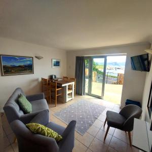 a living room with a couch and chairs and a desk at Seaside haven in Simonʼs Town +15 photos