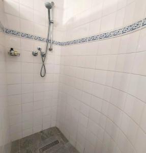 a white tiled shower with a shower head at Seaside haven in Simonʼs Town