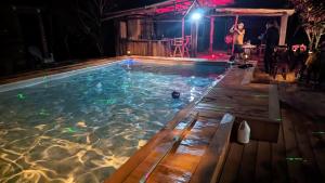 a man standing next to a swimming pool at night at Hidden Paradise Belize in White Hill